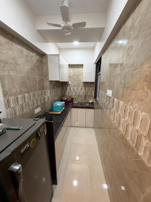 a large kitchen with a counter and a ceiling at Creek View Studio Apartment in Mumbai