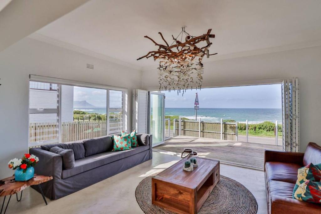 a living room with a couch and a table at 78 Beach Road - Seafront luxury bliss in Kleinmond