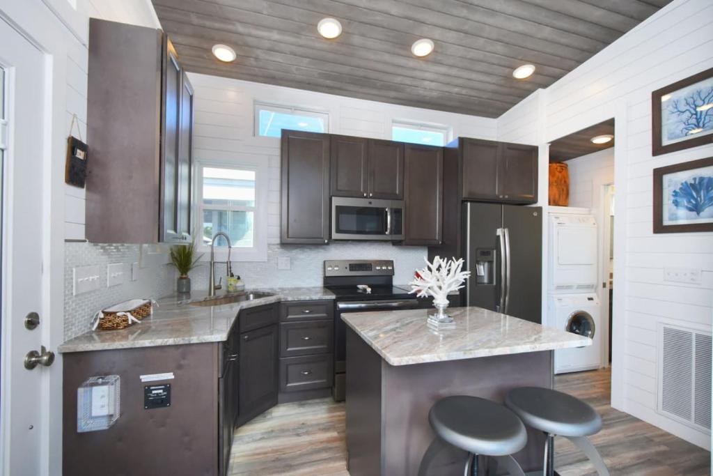 a kitchen with stainless steel appliances and brown cabinets at TV Blue Tiny Houseboat at Lake Cumberland Marina in Nancy
