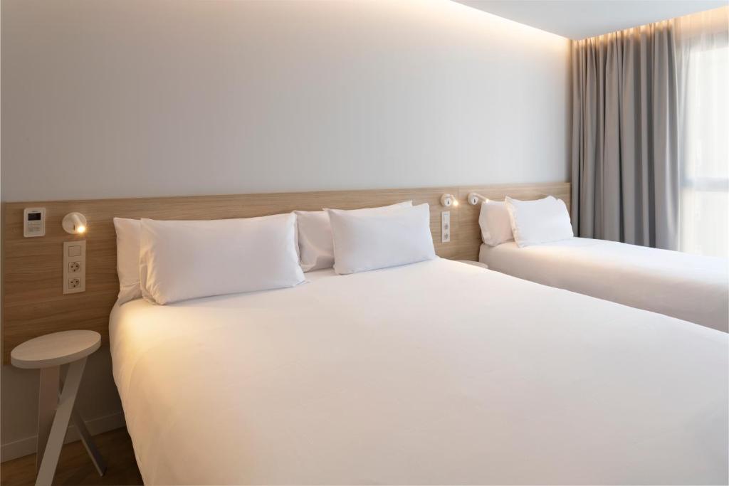 a hotel room with two beds and a window at B&B HOTEL Alicante Centro in Alicante