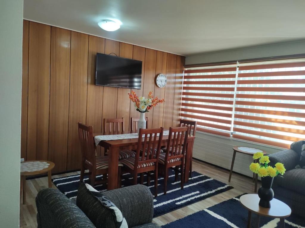 a living room with a table and chairs and a tv at Garcia hurtado departamento diario in Osorno
