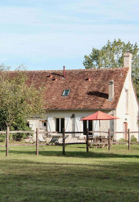 une grande maison blanche avec une table de pique-nique devant elle dans l'établissement Maison Moz, à Fontaines-en-Sologne