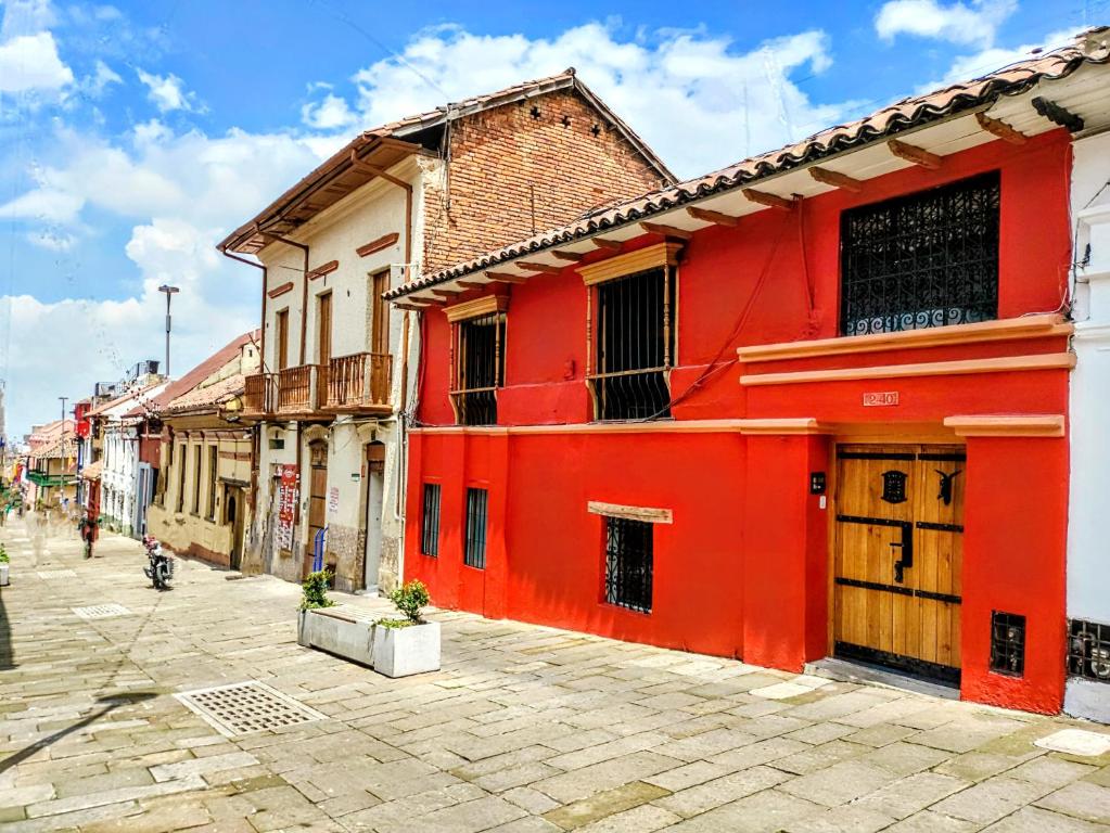 un edificio rojo al lado de una calle en Apartaestudios La Candelaria, en Bogotá