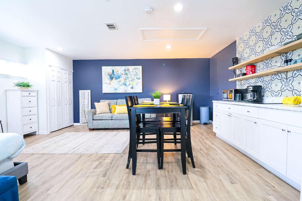 eine Küche und ein Wohnzimmer mit einem Tisch und einer Couch in der Unterkunft NEW5 LUXURYSTUDIO Nr DISNEY PETSOKprivENTRY in Kissimmee
