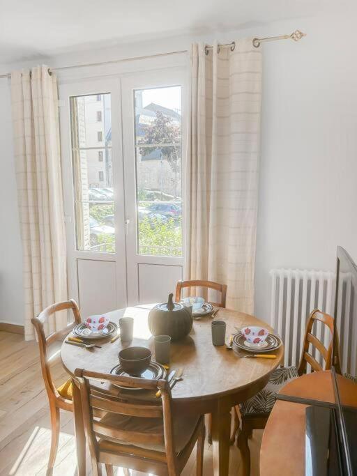 - une table à manger avec des chaises et une table avec une théière dans l'établissement L'Ecrin de la Jolie, à Mantes-la-Jolie