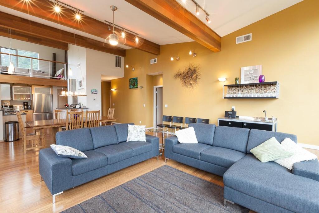 a living room with two blue couches and a kitchen at Mountain House in Mount Hood