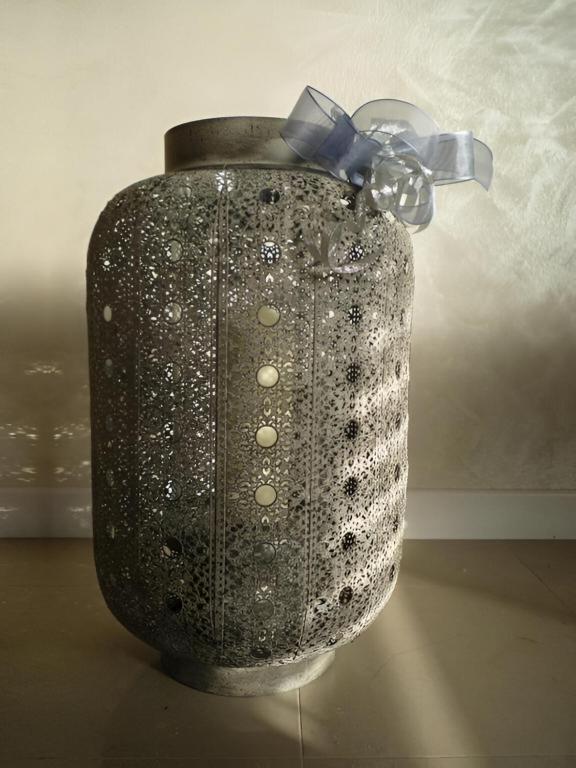 a black vase with a blue bow on it at Csiki Hotel in Miercurea-Ciuc