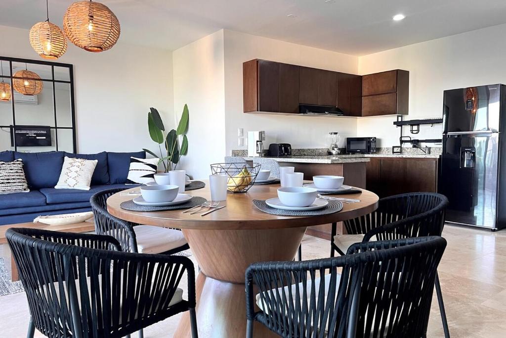 a living room with a table with chairs and a kitchen at Condo Playa & Waterfront Heated Alberca in Mazatlán