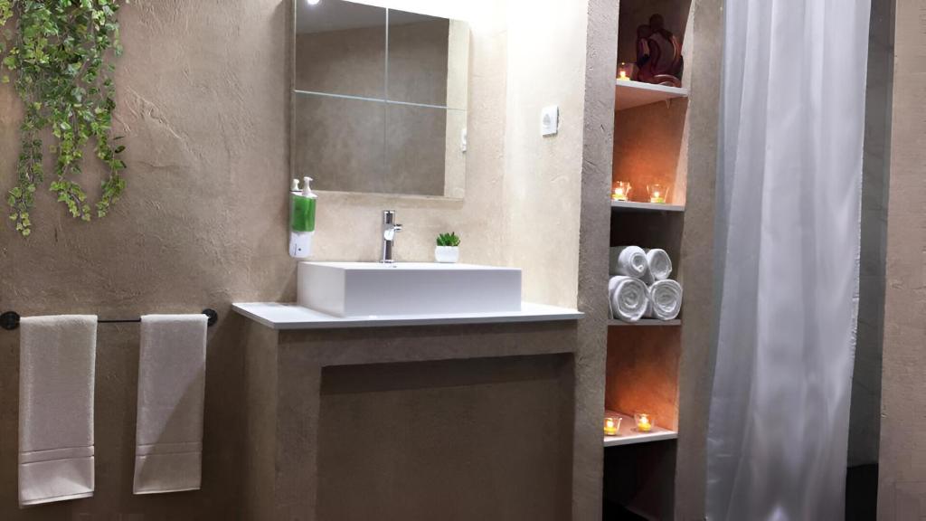 a bathroom with a white sink and a mirror at Csiki Hotel in Miercurea-Ciuc