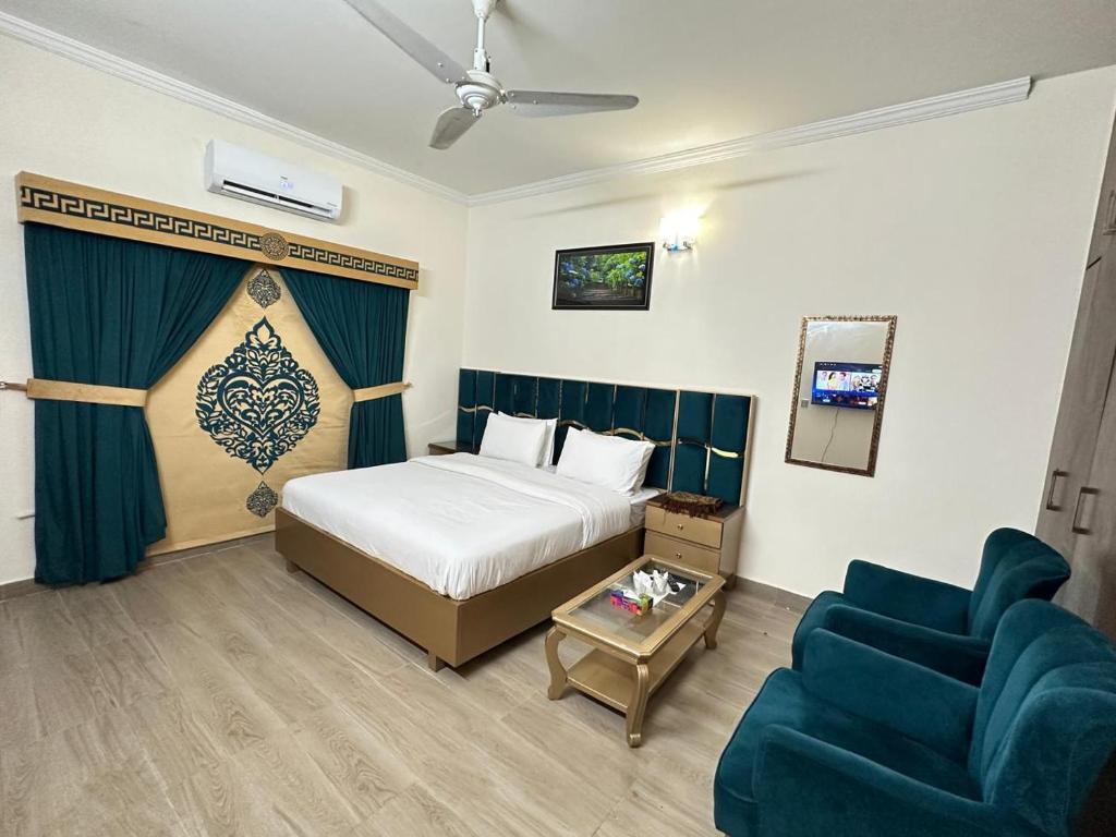 a hotel room with a bed and a couch at Travis Executive Guest House Islamabad in Islamabad