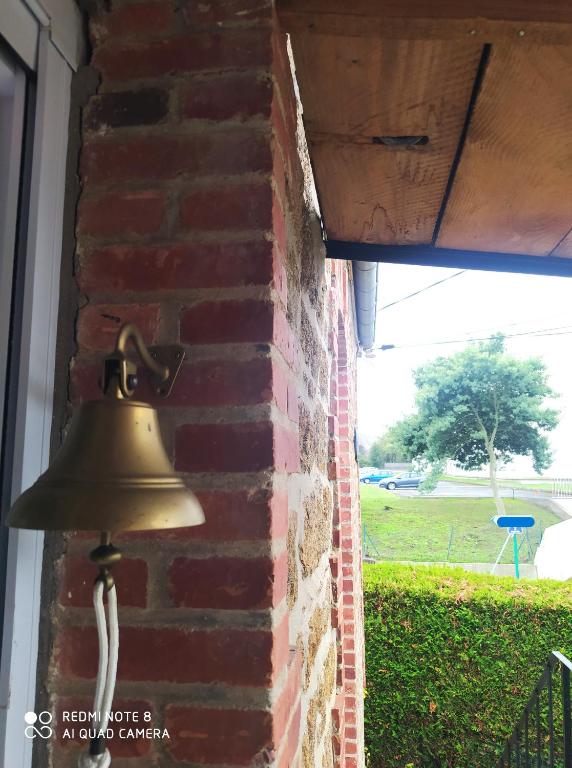 une cloche sur le côté d'un mur de briques dans l'établissement appartement dans maison de caractère en pierre, à Saint-Malo
