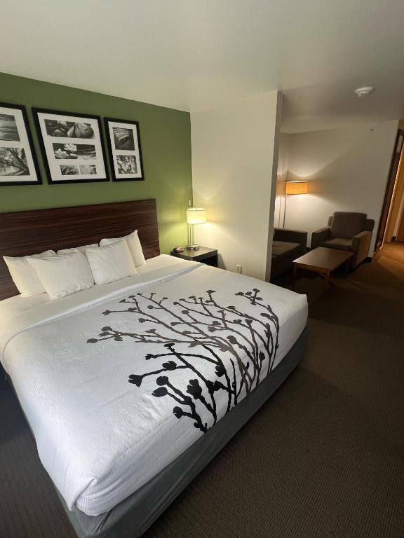 a hotel room with a bed with a tree on it at Sleep Inn & Suites Conference Center Eau Claire North in Union