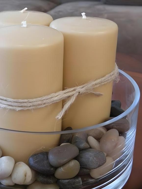 a candle holder with candles and rocks at Csiki Hotel in Miercurea-Ciuc