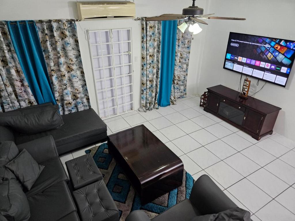 a living room with a couch and a flat screen tv at 3 bedroom townhouse in Diego Martin