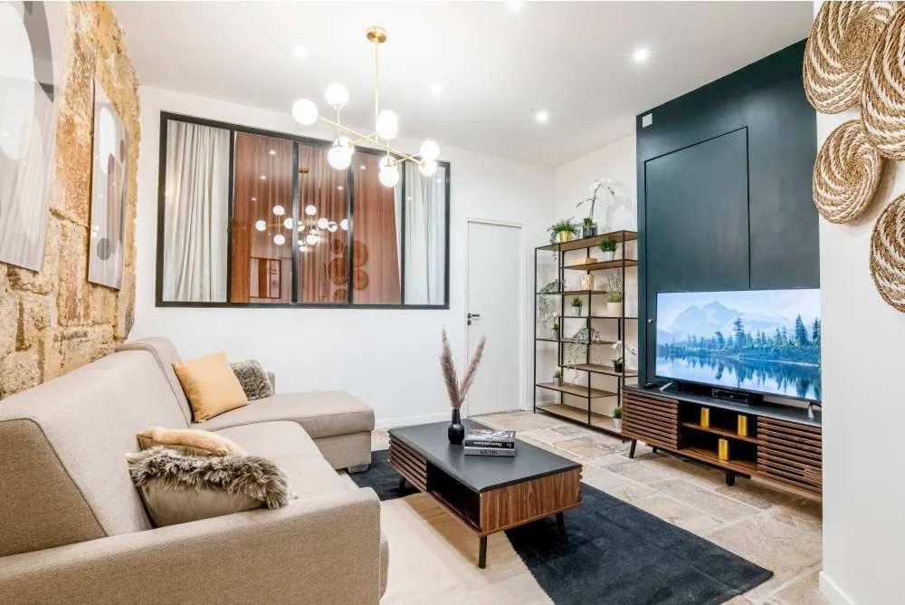 un salon avec un canapé et une télévision à écran plat dans l'établissement Keyz - Spacious 2BD in the heart of Le Marais, à Paris