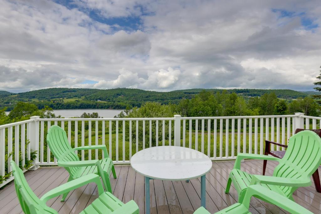 een tafel en stoelen op een terras met uitzicht op een meer bij Private Retreat with Deck 1 Mi From Cowanesque Lake in Lawrenceville