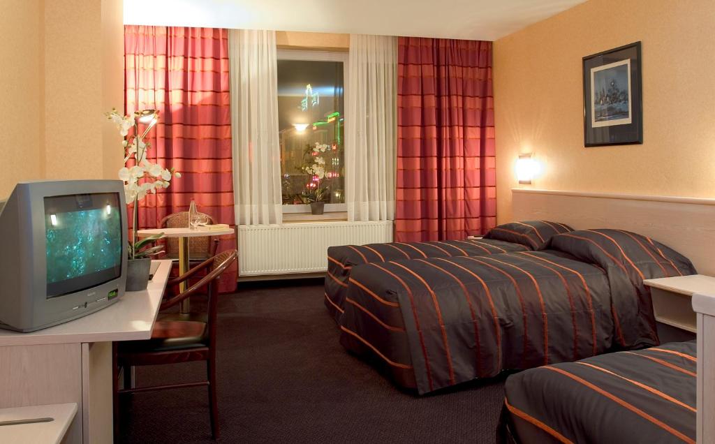 TV a/nebo společenská místnost v ubytování Hotel Leo Station, Villa et Annexes