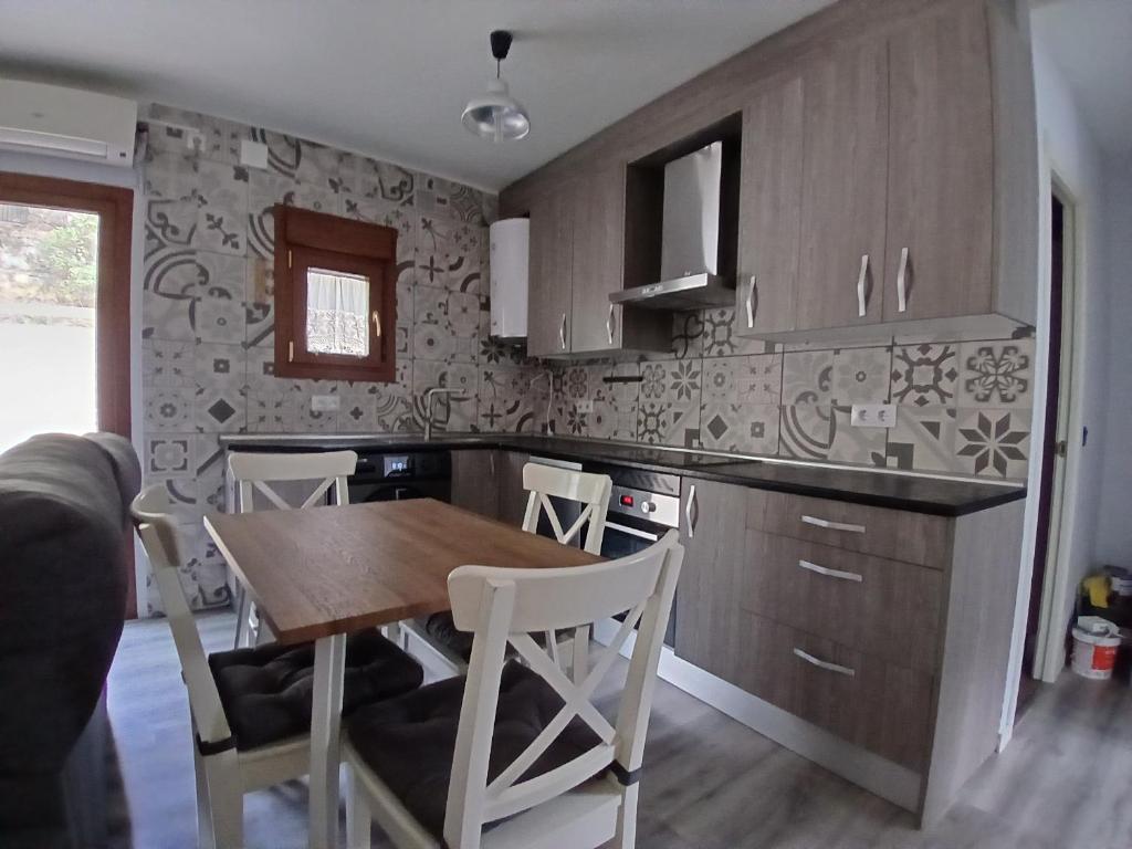 a kitchen with a wooden table and a table and chairs at Entrepinos in Guisando