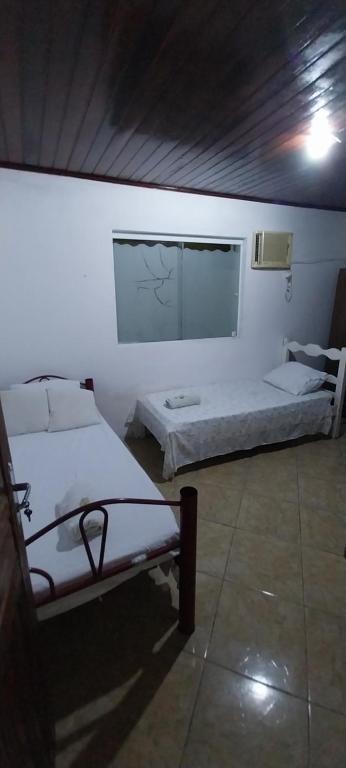 Postel nebo postele na pokoji v ubytování CASA DE HOSPEDAGEM FLORES PARATY AMBIENTE FAMILIAR 600M DO CENTRO e COM CAFÉ DA MANHÃ INCLUSO CASA COMPLETA