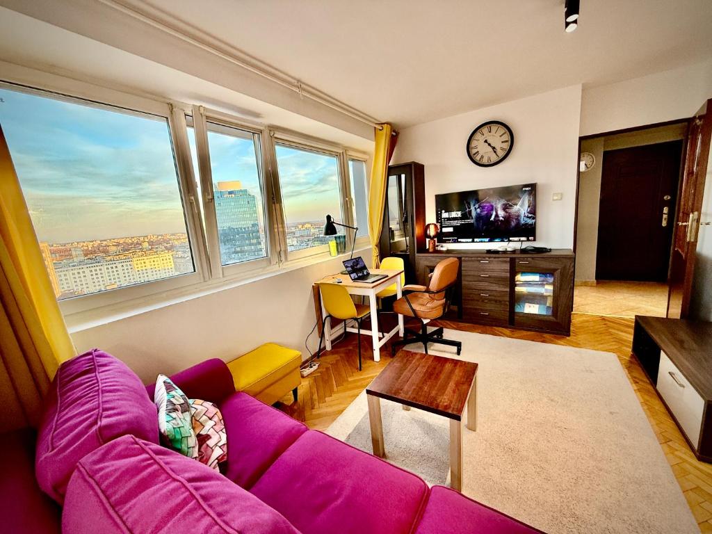 ein Wohnzimmer mit einem lila Sofa und einem Tisch in der Unterkunft Super Apartment YELLOW 2x Metro fast Wifi 1 Gbs Netflix Panorama Miasta in Warschau
