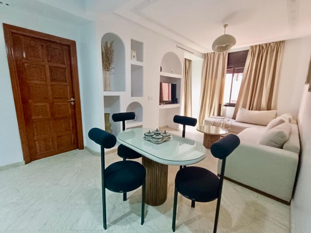 a living room with a table and chairs and a couch at Cosy appartement au cœur de Gueliz in Marrakech