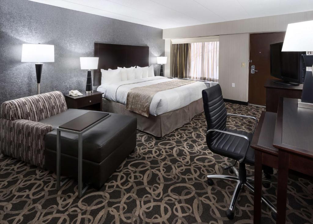 a hotel room with a bed and a desk and chair at Best Western Ramkota Hotel Aberdeen in Aberdeen