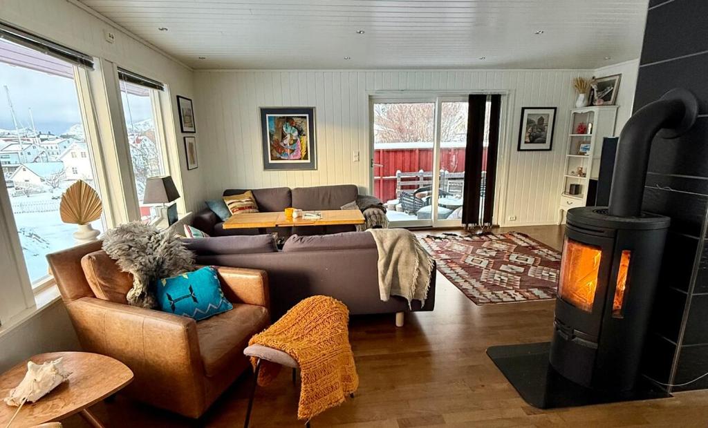 ein Wohnzimmer mit einem Sofa und einem Holzofen in der Unterkunft Perfect house in Henningsvær with sea-view in Henningsvær