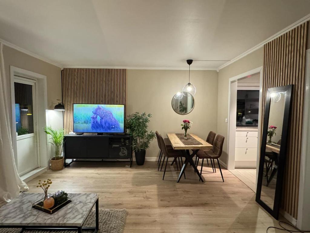 a living room with a table and a television at Koselig leilighet på Østensjø med stor uteplass in Oslo