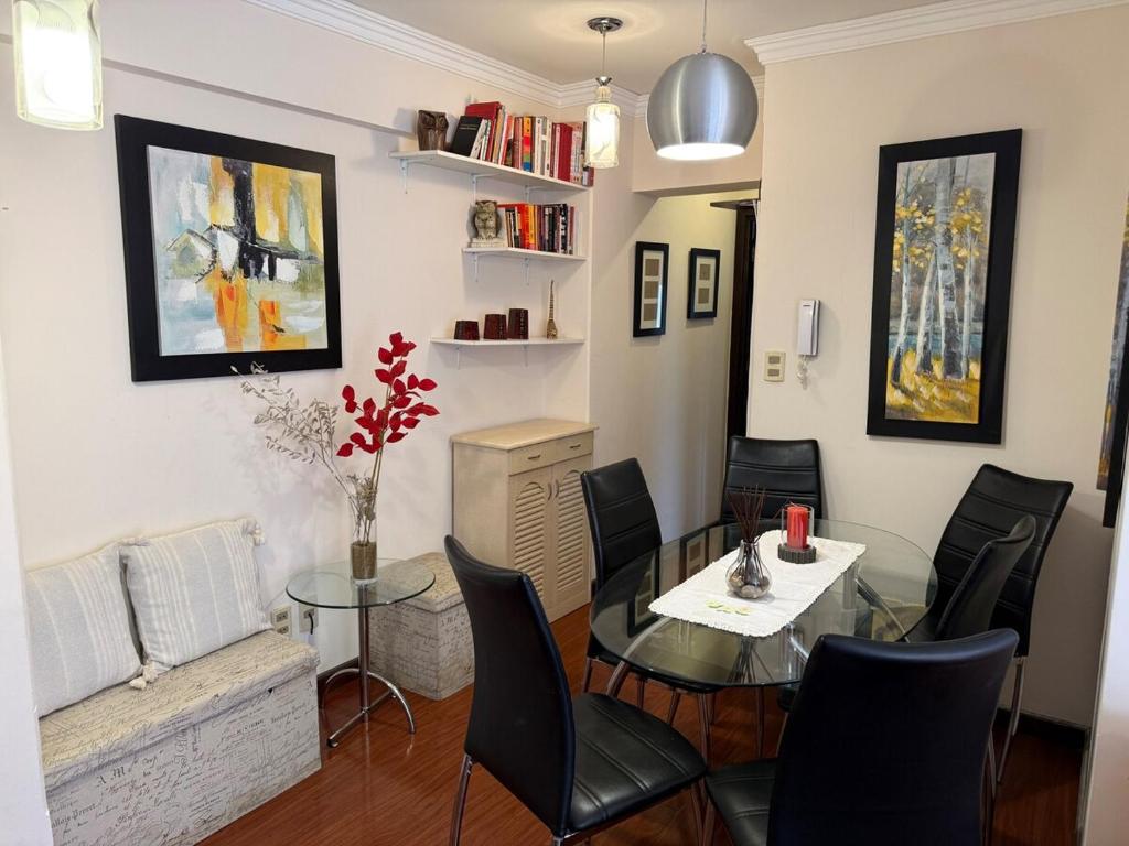a dining room with a glass table and black chairs at 1D apartment in the best area of La Paz in La Paz