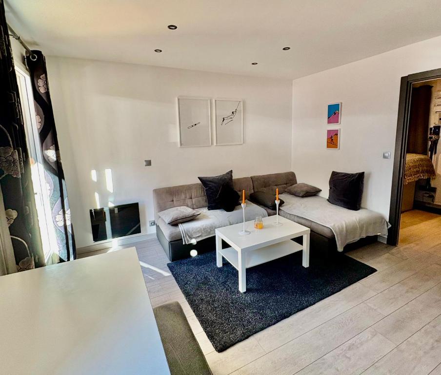 un salon avec un canapé et une table dans l'établissement Appartement moderne et entièrement rénové en plein cœur du village, chambre séparée, balcon vue montagne, très proche des pistes, à Tignes