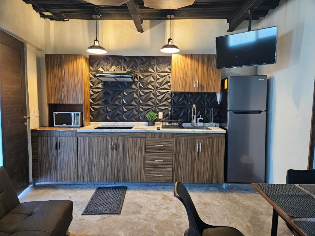a kitchen with wooden cabinets and a refrigerator at Relaxed and private in Jiquilpan de Juárez