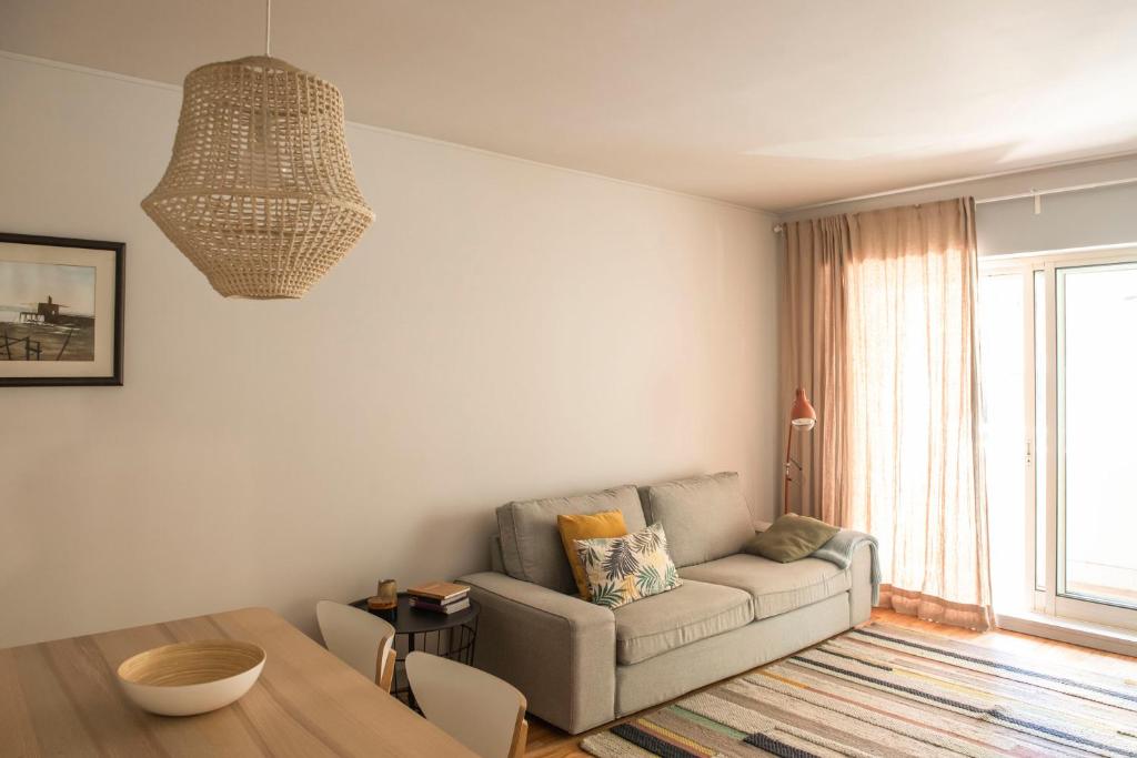 een woonkamer met een bank en een tafel bij Apartamento Mira Foz in Matosinhos