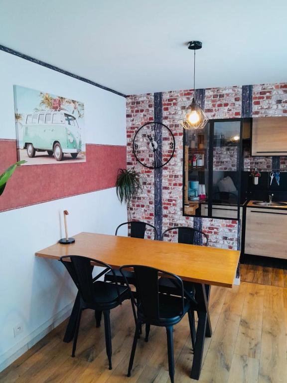 une salle à manger avec une table et des chaises en bois dans l'établissement Petit nid perché très cosy au centre de Béziers, à Béziers