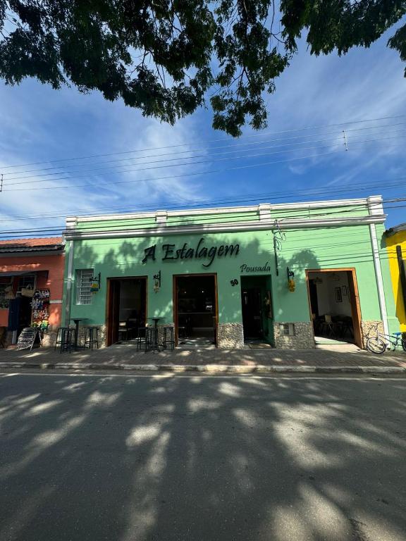 a green building with a sign that reads a library at A Estalagem Pousada in Monteiro Lobato