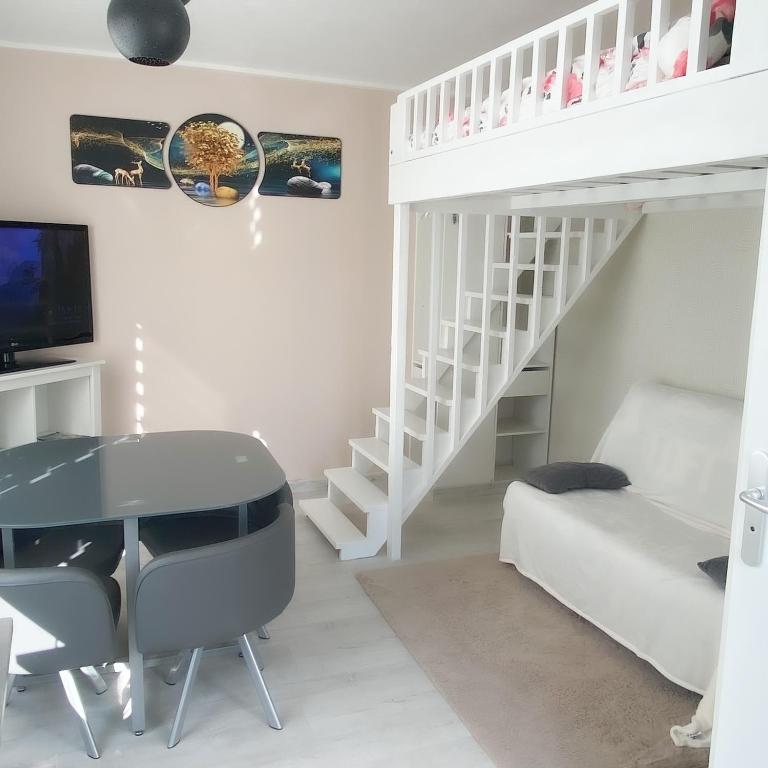 Cette chambre blanche dispose d'un bureau et de lits superposés. dans l'établissement Studio Cosy, à Saintes