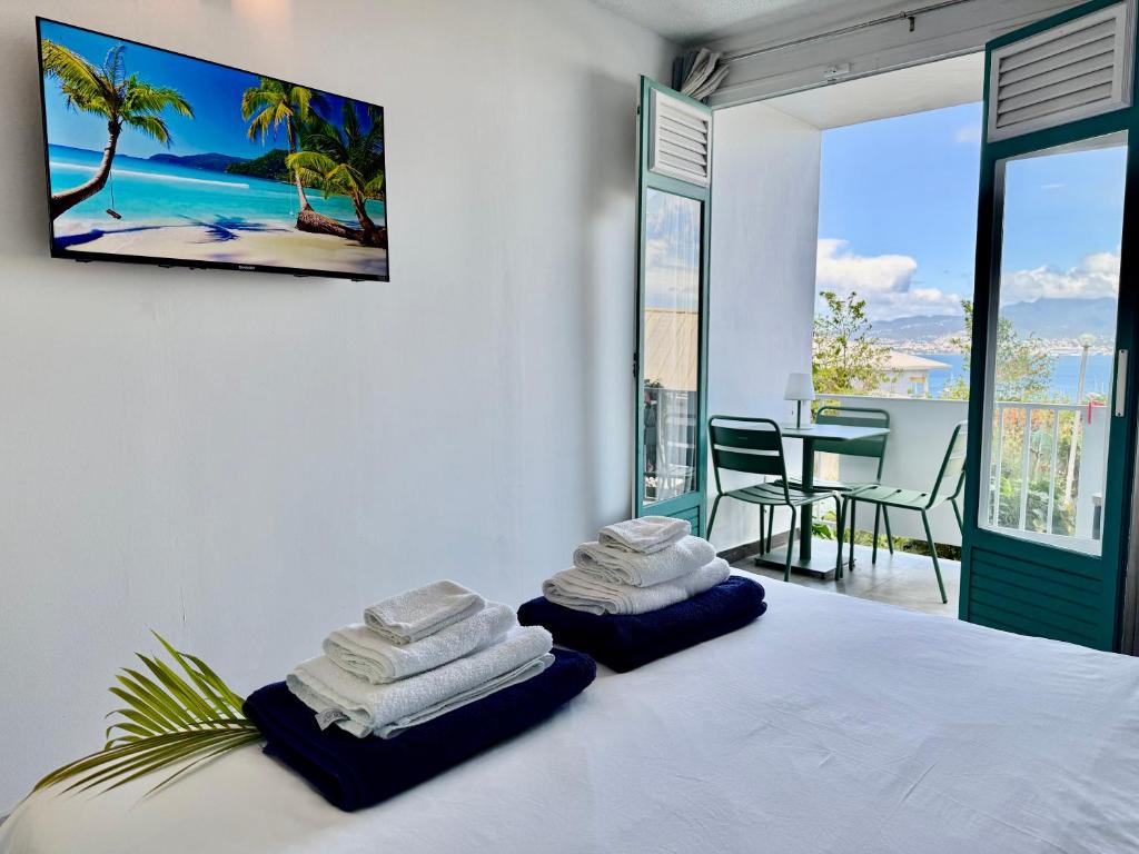 a bedroom with a bed with towels on it at Suite Caraïbes 1 - Superbe Studio Cosy in Les Trois-Îlets
