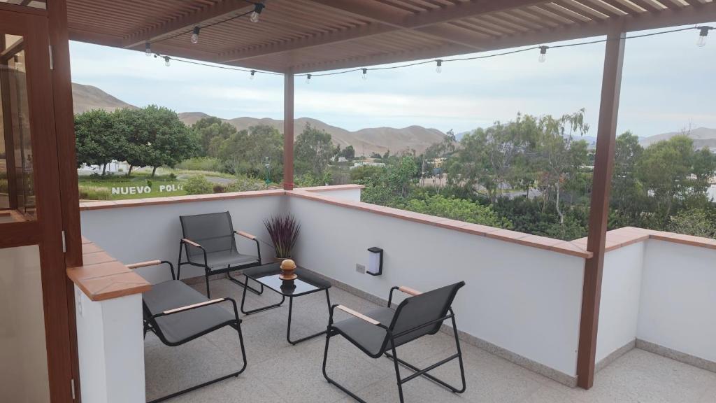 a balcony with chairs and a table with a view at Casa de campo en condo cerca a playa Puerto Viejo in San Antonio