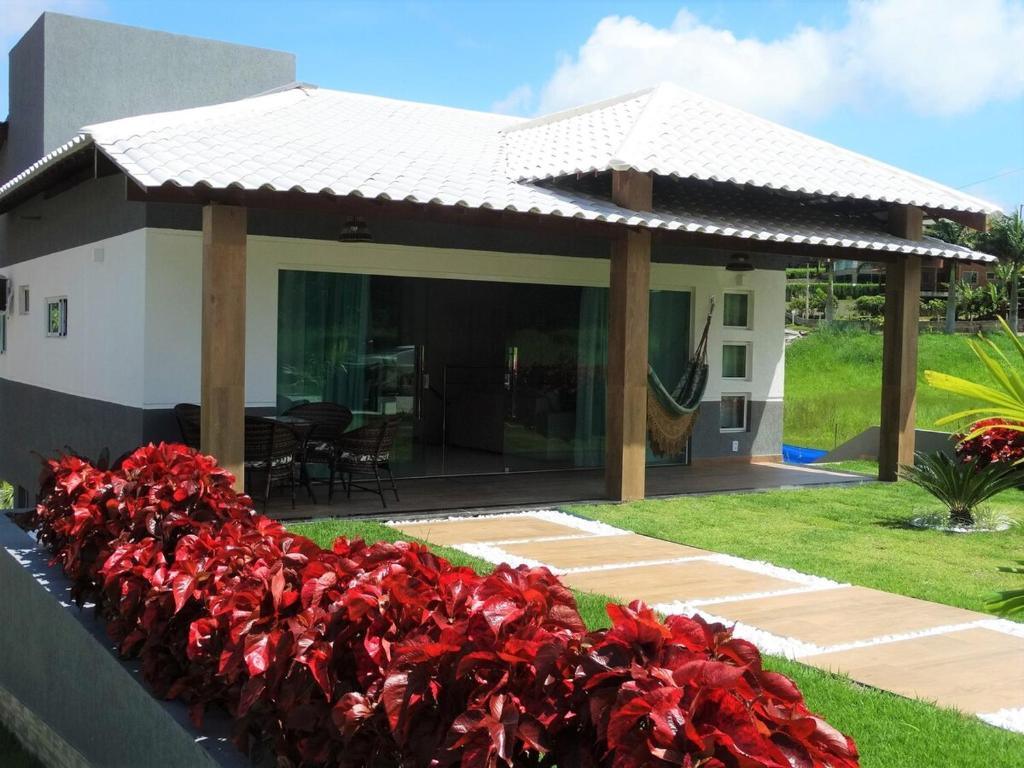 een huis met rode bloemen ervoor bij Casa na Serra - paz e natureza in Chã Grande