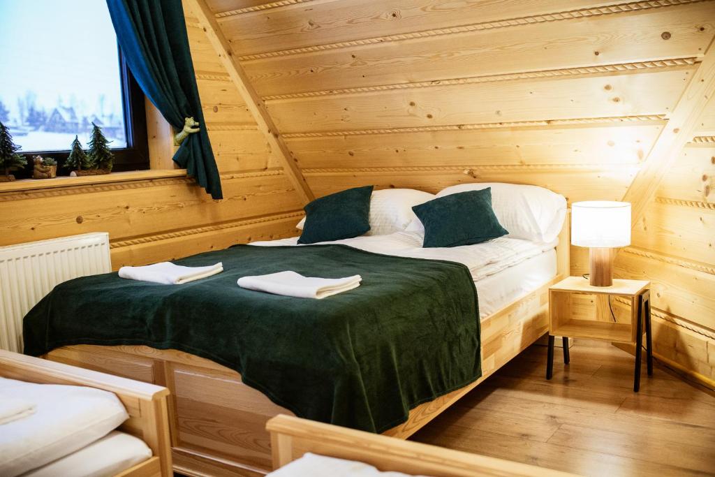 Ένα ή περισσότερα κρεβάτια σε δωμάτιο στο Domki Trzy Smreki