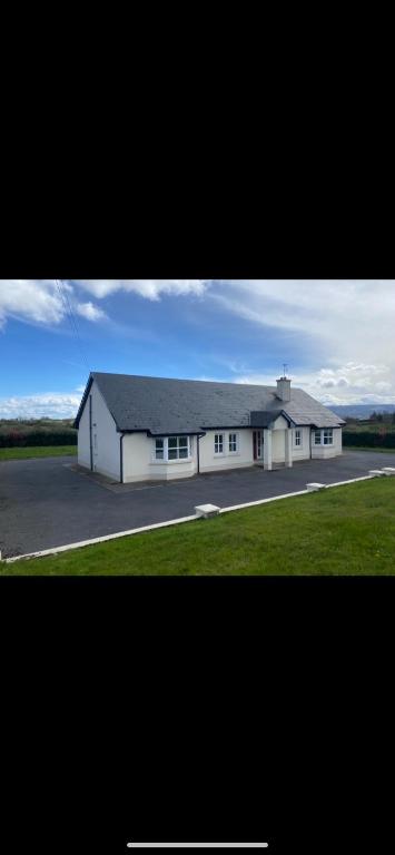a large white building with a garage at Cosy East Clare Apartment in Coolcoosaun