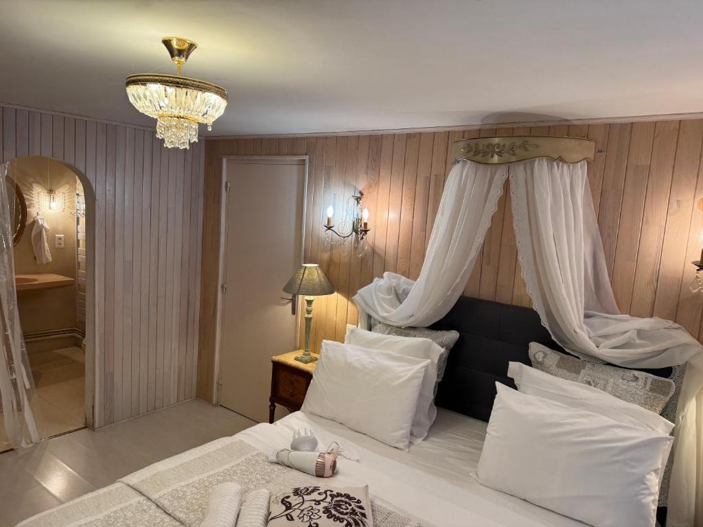 une chambre avec un grand lit à baldaquin dans l'établissement Chambre d'hôte Petit déjeuner, Sauna et Piscine inclus Jacuzzi en option, à Sarlat-la-Canéda