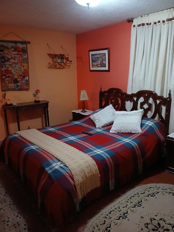 a bedroom with a bed with red walls at Casa de la montaña El Pedregal de Sopó in Sopo