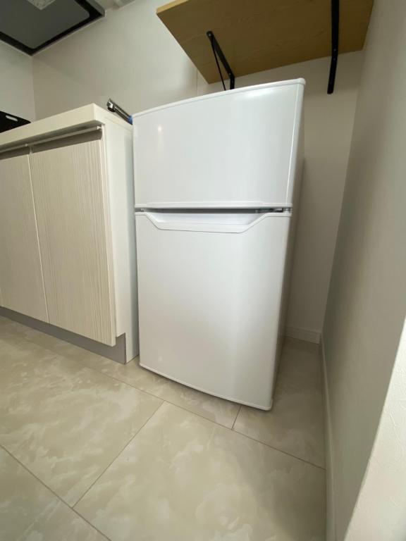 a white refrigerator in a kitchen with a counter at 吉祥寺千利休302号室 in Musashino