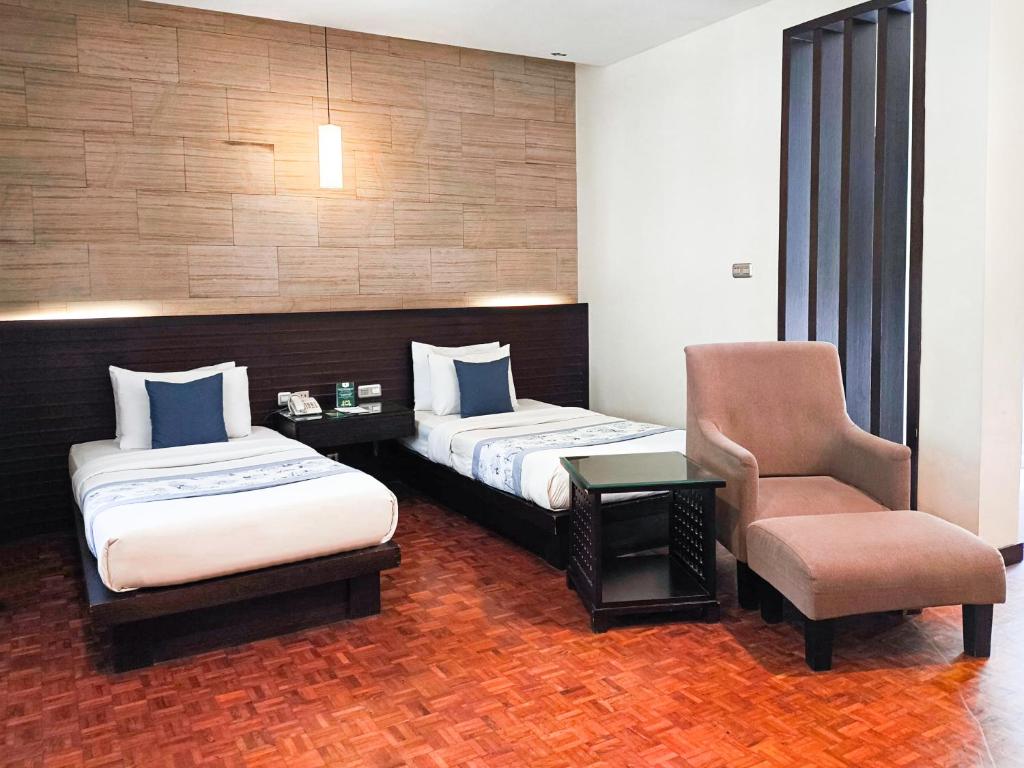 Postel nebo postele na pokoji v ubytování Puteri Gunung Hotel