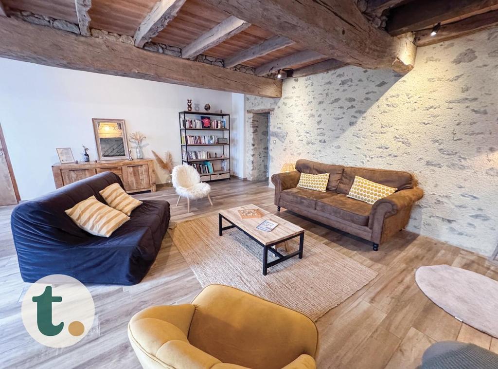 un salon avec deux canapés et une table dans l'établissement Tranquiloue - Maison spacieuse à 8min du PuyduFou, à Saint-Laurent-sur-Sèvre