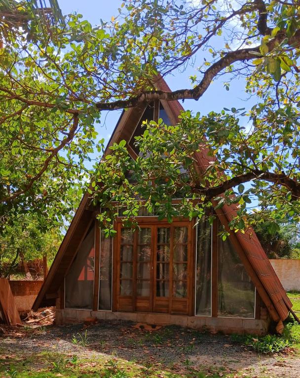 a house with glass doors and a tree at Cabana Villa Caju in Praia dos Algodões