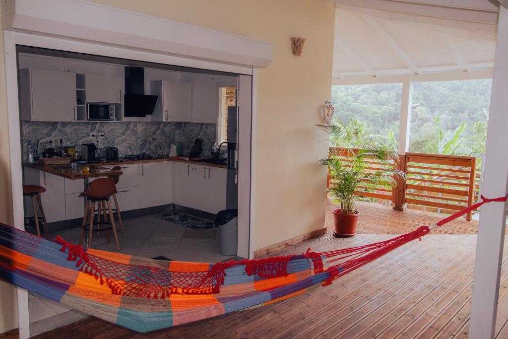 a living room with a hammock in the middle of a kitchen at la Canne a sucre in Pointe-Noire