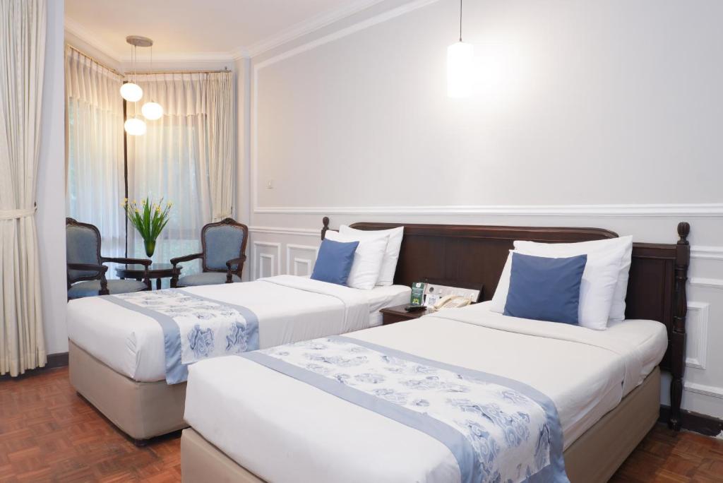 Postel nebo postele na pokoji v ubytování Puteri Gunung Hotel