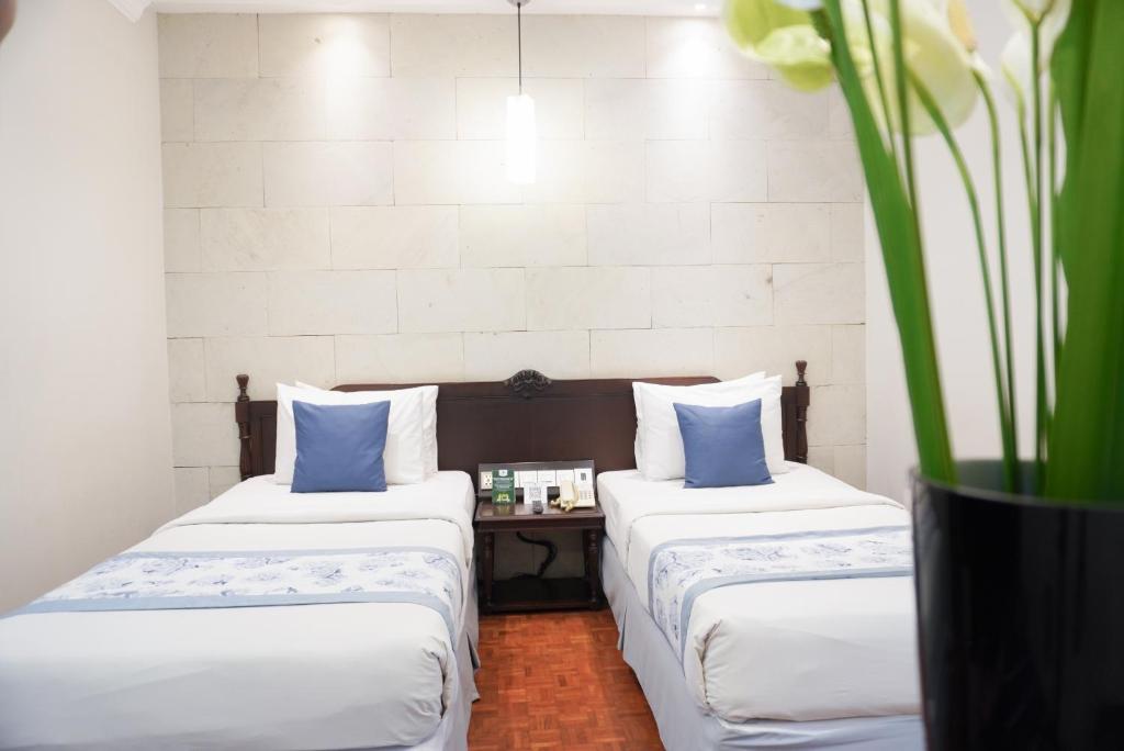 Postel nebo postele na pokoji v ubytování Puteri Gunung Hotel