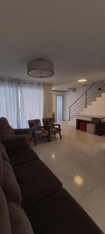 a living room with a couch and a piano at Casa duplex, 400m da praia e 13min do Beto Carrero in Piçarras